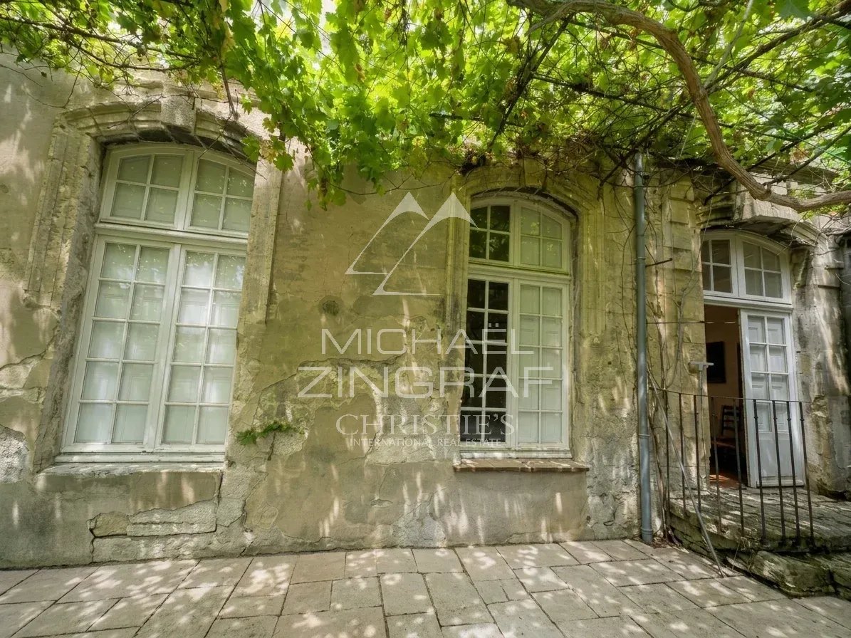 Façade d'un hôtel particulier à rénover à Avignon, avec fenêtres et treillis de vigne.