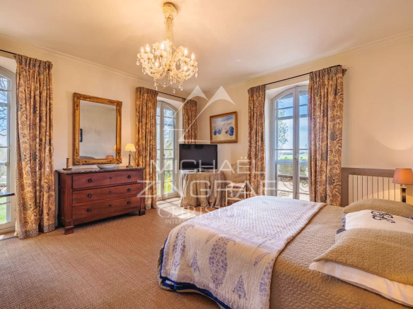 Bright room with double bed and windows offering a view of the park.