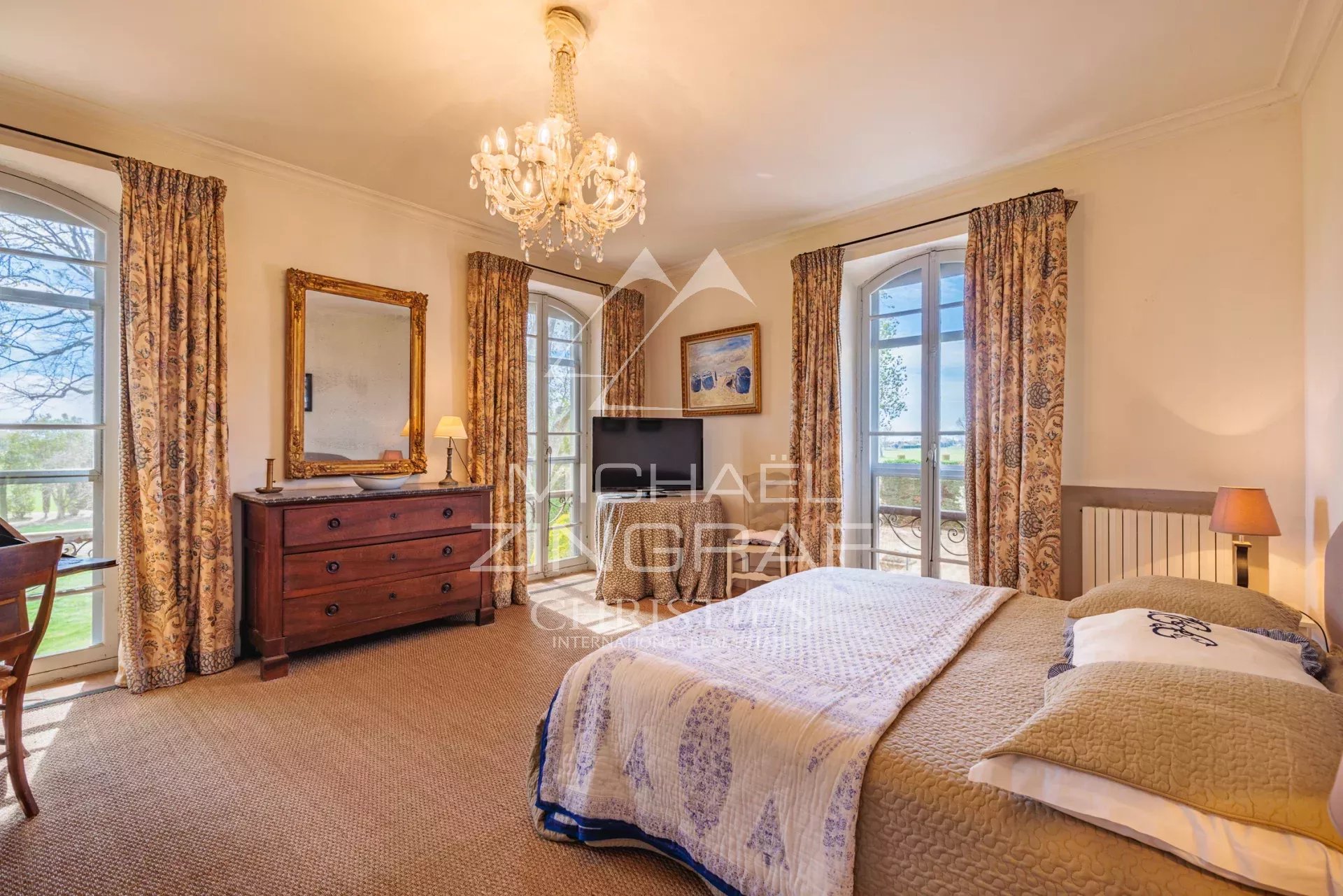 Bright room with double bed and windows offering a view of the park.