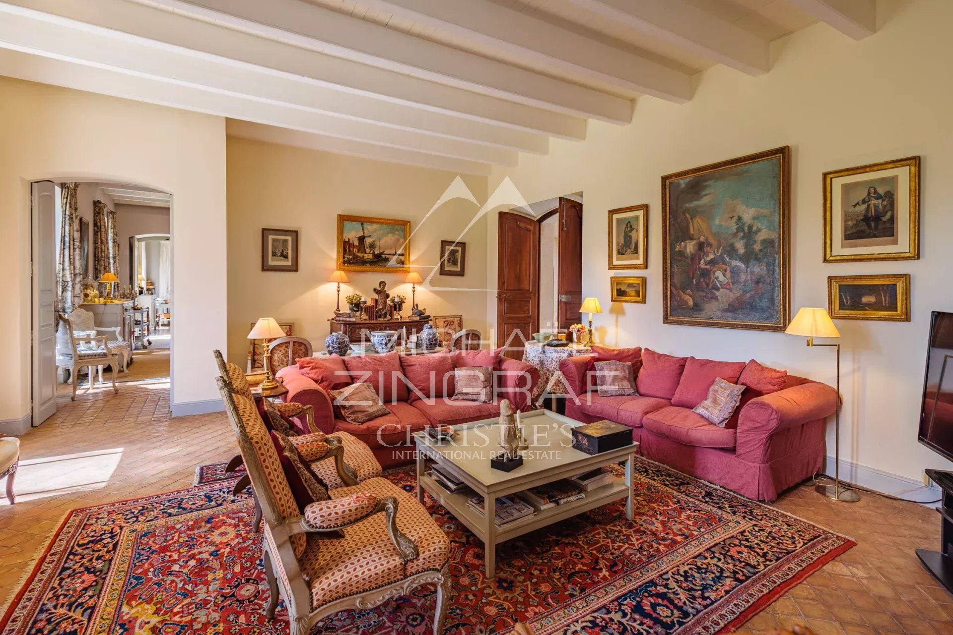 Interior of a bright living room with a pink sofa and Provençal decor in a property in Arles.