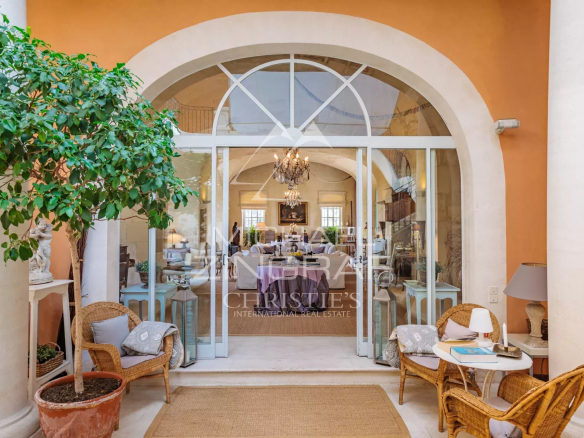 Entrance to a sumptuous property with wicker chairs and refined decor.