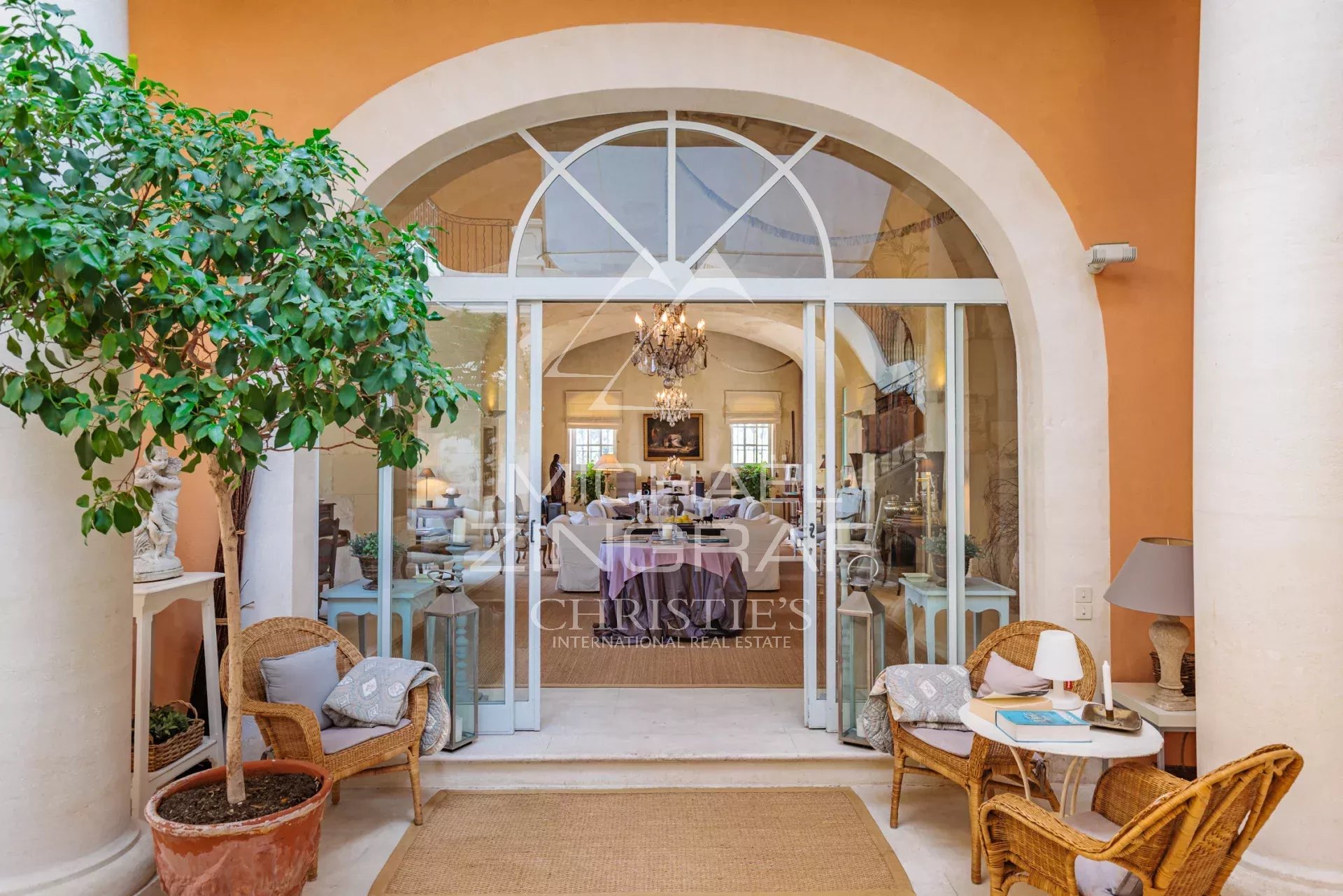 Entrance to a sumptuous property with wicker chairs and refined decor.