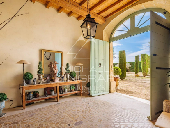 Entrance to a Provençal property with a stone floor and elegant decorations.