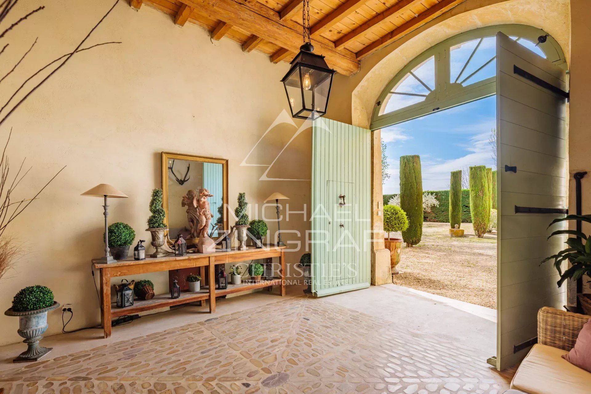 Entrance to a Provençal property with a stone floor and elegant decorations.