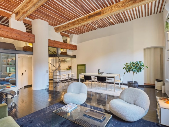 Intérieur d'un appartement rénové avec poutres apparentes et mobilier moderne à Aix-en-Provence.