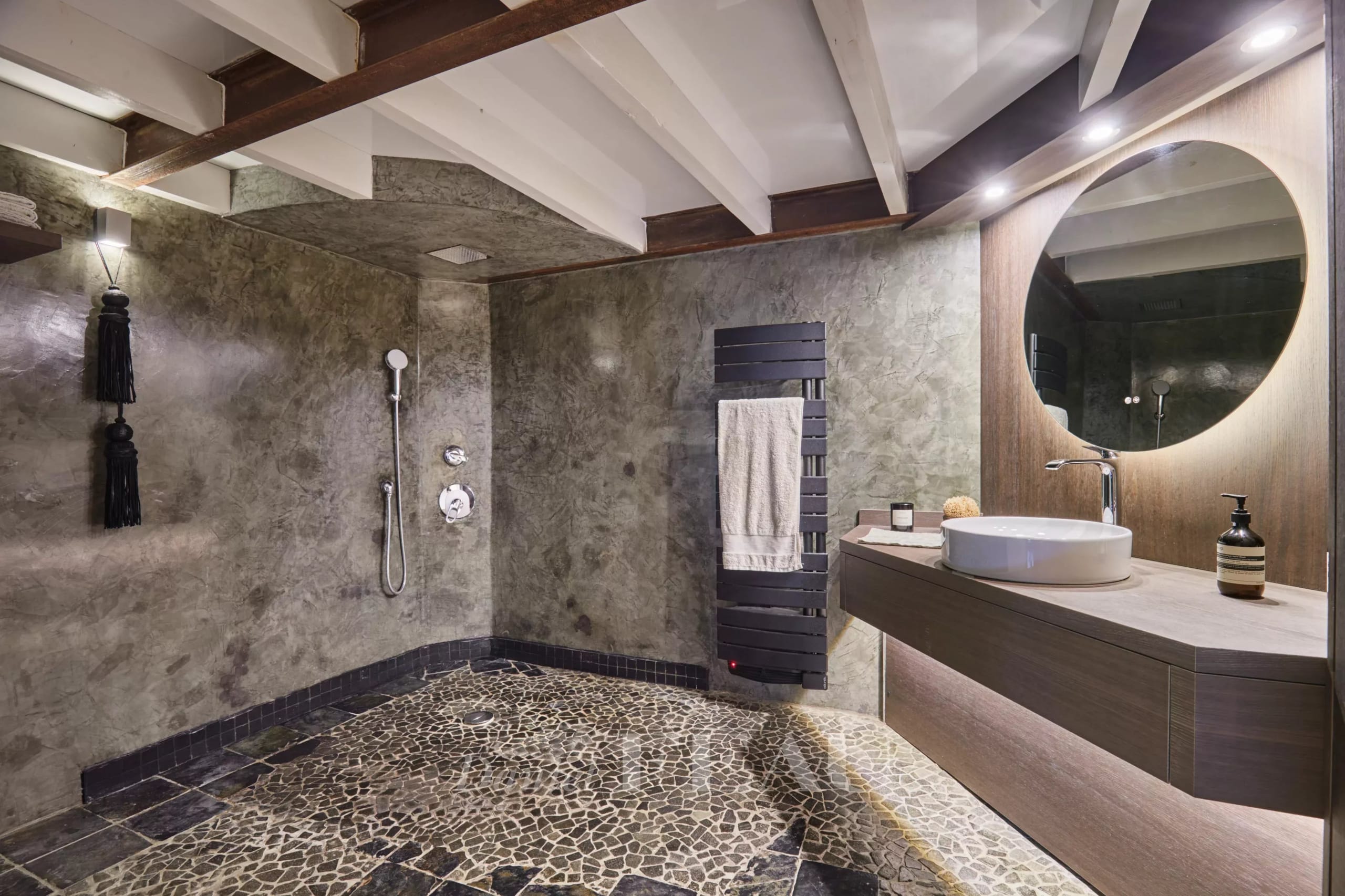 Salle de bain moderne avec douche et lavabo dans un appartement rénové à Aix-en-Provence.
