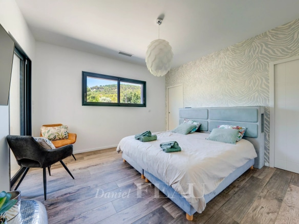 Chambre lumineuse avec lit double et vue sur la campagne, décor moderne.
