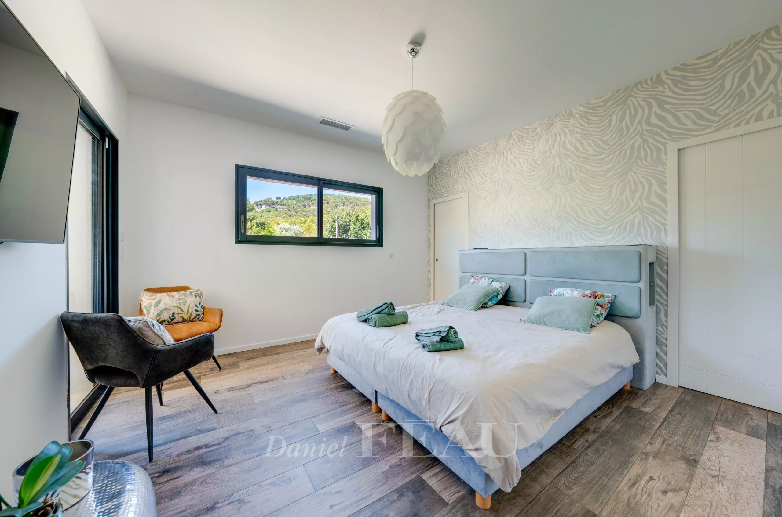 Chambre lumineuse avec lit double et vue sur la campagne, décor moderne.