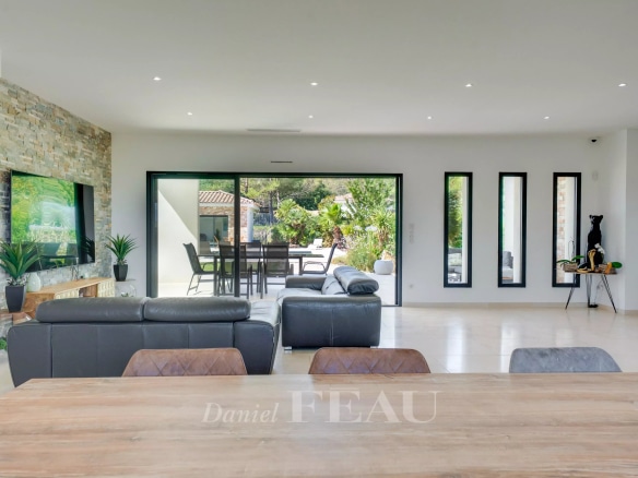 Intérieur d'une maison contemporaine avec salon lumineux et vue sur le jardin.