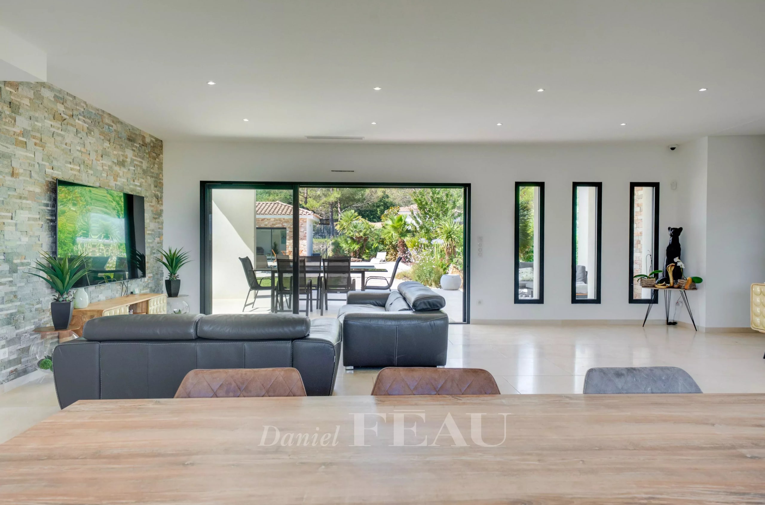 Intérieur d'une maison contemporaine avec salon lumineux et vue sur le jardin.