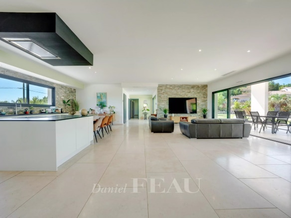 Intérieur d'une propriété contemporaine avec cuisine ouverte et salon lumineux.