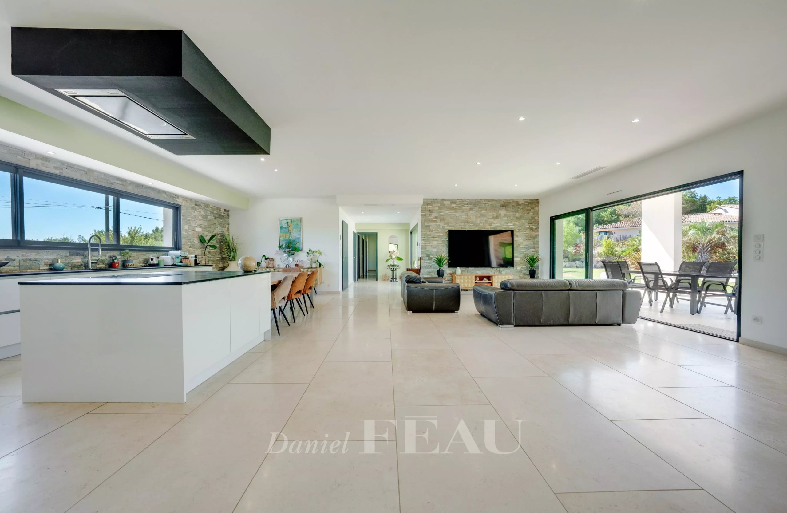 Intérieur d'une propriété contemporaine avec cuisine ouverte et salon lumineux.