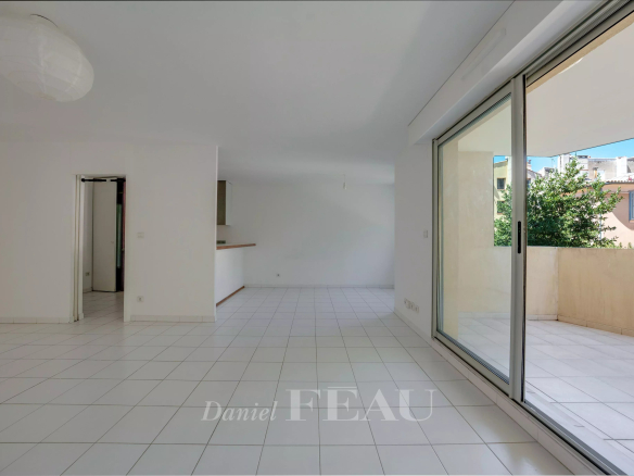 Intérieur d'un appartement à Aix-en-Provence avec terrasse et sol en carrelage blanc.