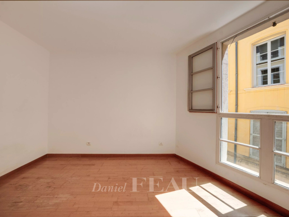 Intérieur d'un appartement à Aix-en-Provence avec lumière naturelle et fenêtres ouvertes.