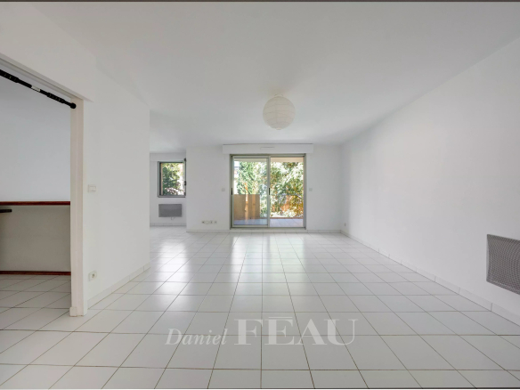 Intérieur d'un appartement à Aix-en-Provence avec carrelage blanc et accès à une terrasse.