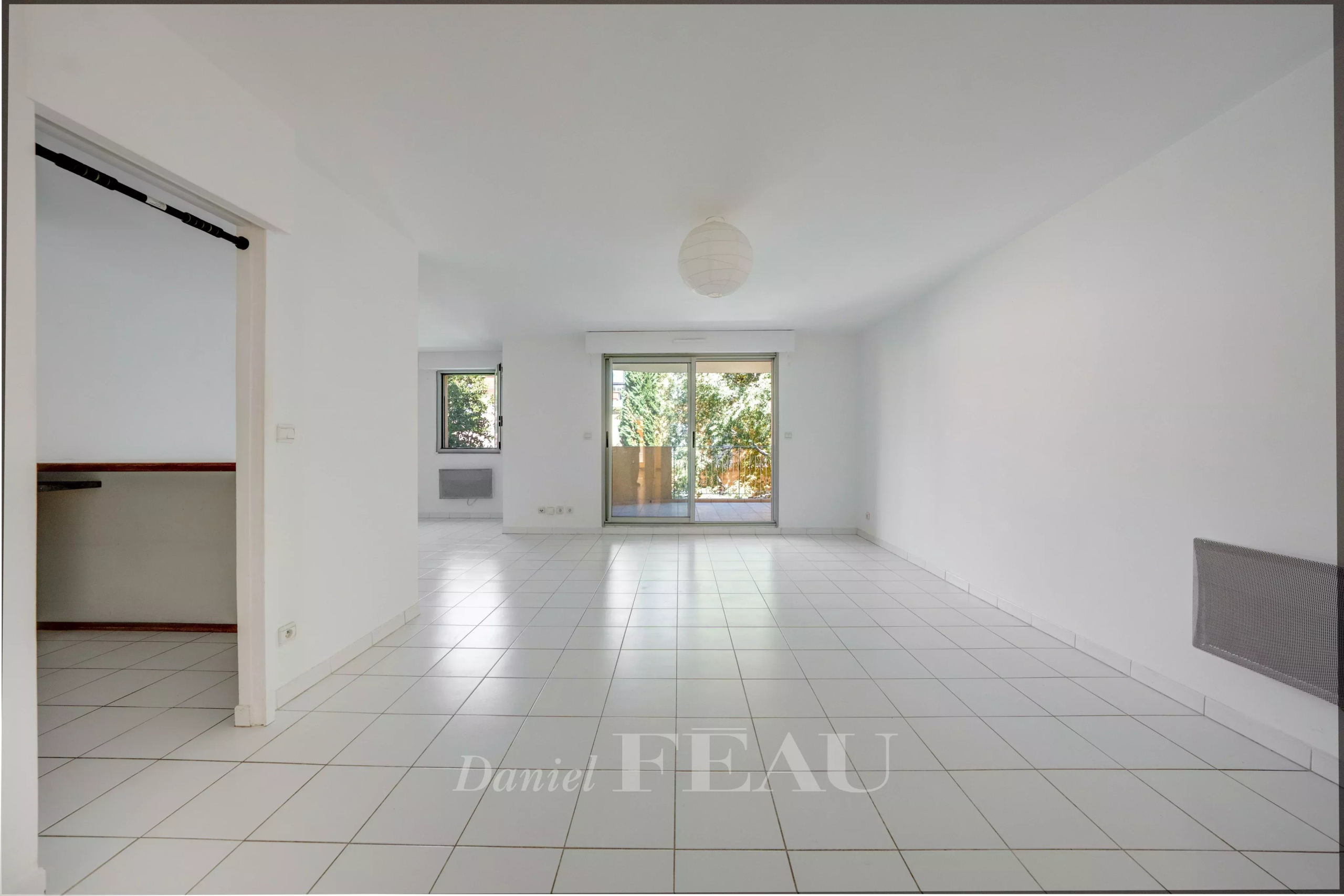 Appartement à Aix-en-Provence Intérieur d'un appartement à Aix-en-Provence avec carrelage blanc et accès à une terrasse.
