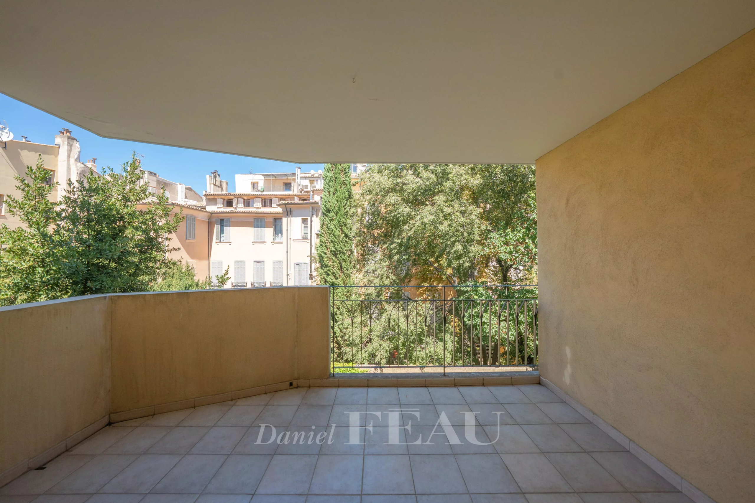 Terrasse d’appartement à Aix-en-Provence Terrasse d'un appartement à Aix-en-Provence avec vue sur des arbres et bâtiments voisins.