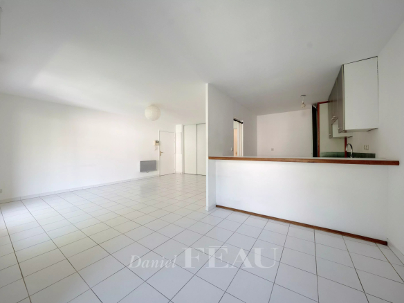 Intérieur d'un appartement spacieux à Aix-en-Provence avec carrelage et cuisine ouverte.