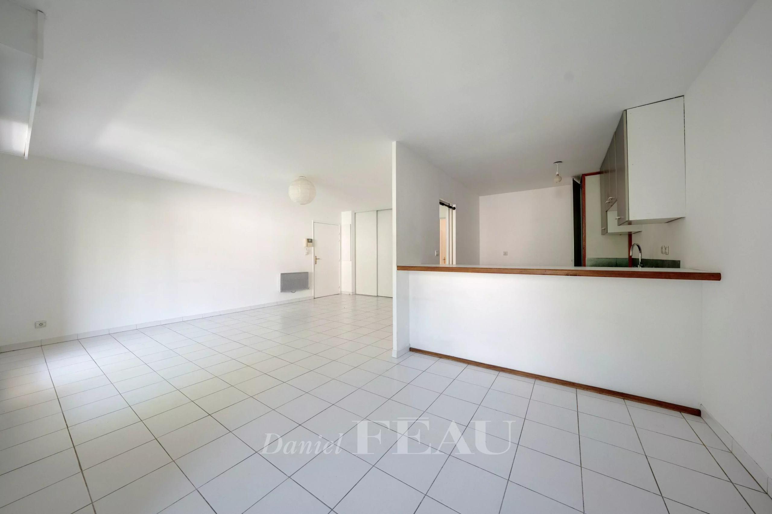 Appartement à Aix-en-Provence Intérieur d'un appartement spacieux à Aix-en-Provence avec carrelage et cuisine ouverte.