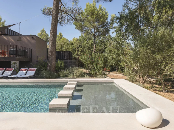 Modern swimming pool in a landscaped park with trees in Aix-en-Provence.