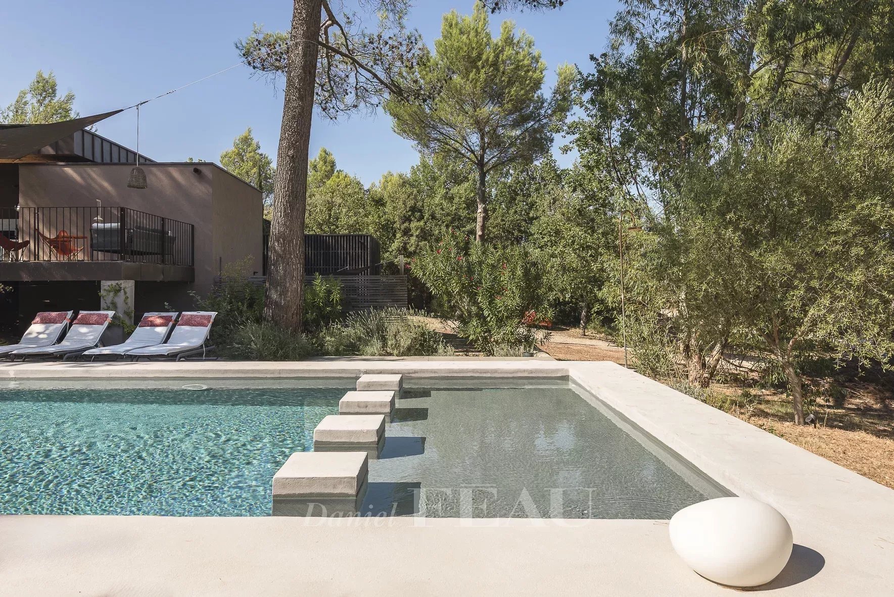Architect-designed house with swimming pool in Aix-en-Provence Modern swimming pool in a landscaped park with trees in Aix-en-Provence.