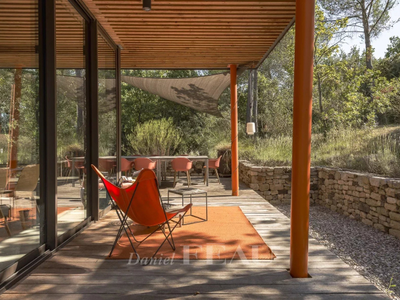 Terrace of an architect-designed house with chairs and a view of the pine forest in Aix-en-Provence.
