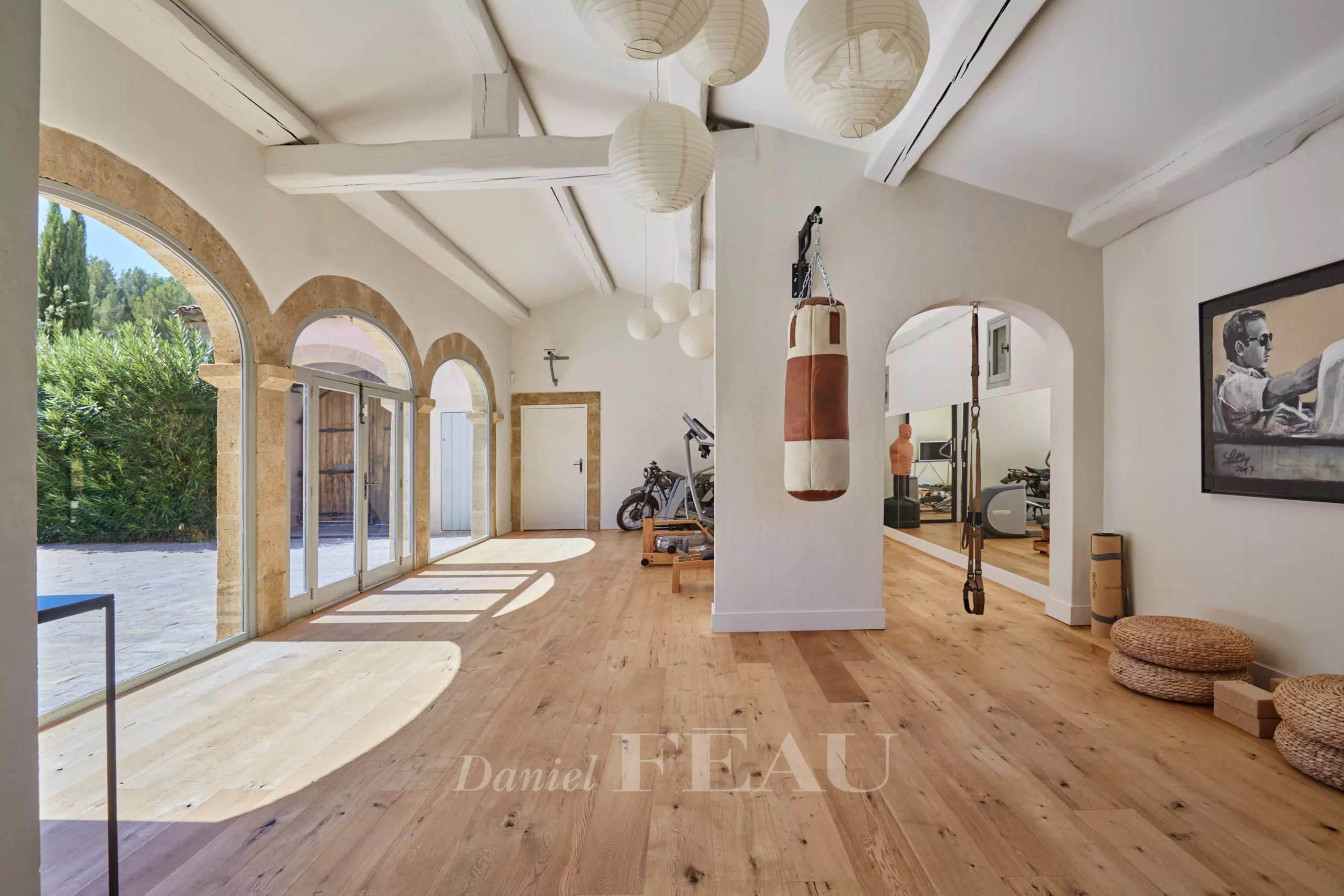Intérieur d'une propriété à Aix-en-Provence avec un sol en bois et des arches décoratives.