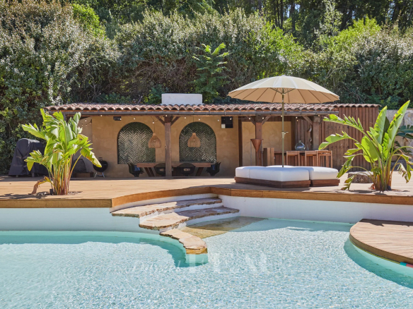 Piscine avec terrasse en bois et pool-house dans une propriété à Aix-en-Provence.