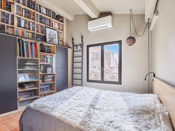 Chambre d'un loft d'architecte à Aix-en-Provence avec bibliothèque et fenêtre.