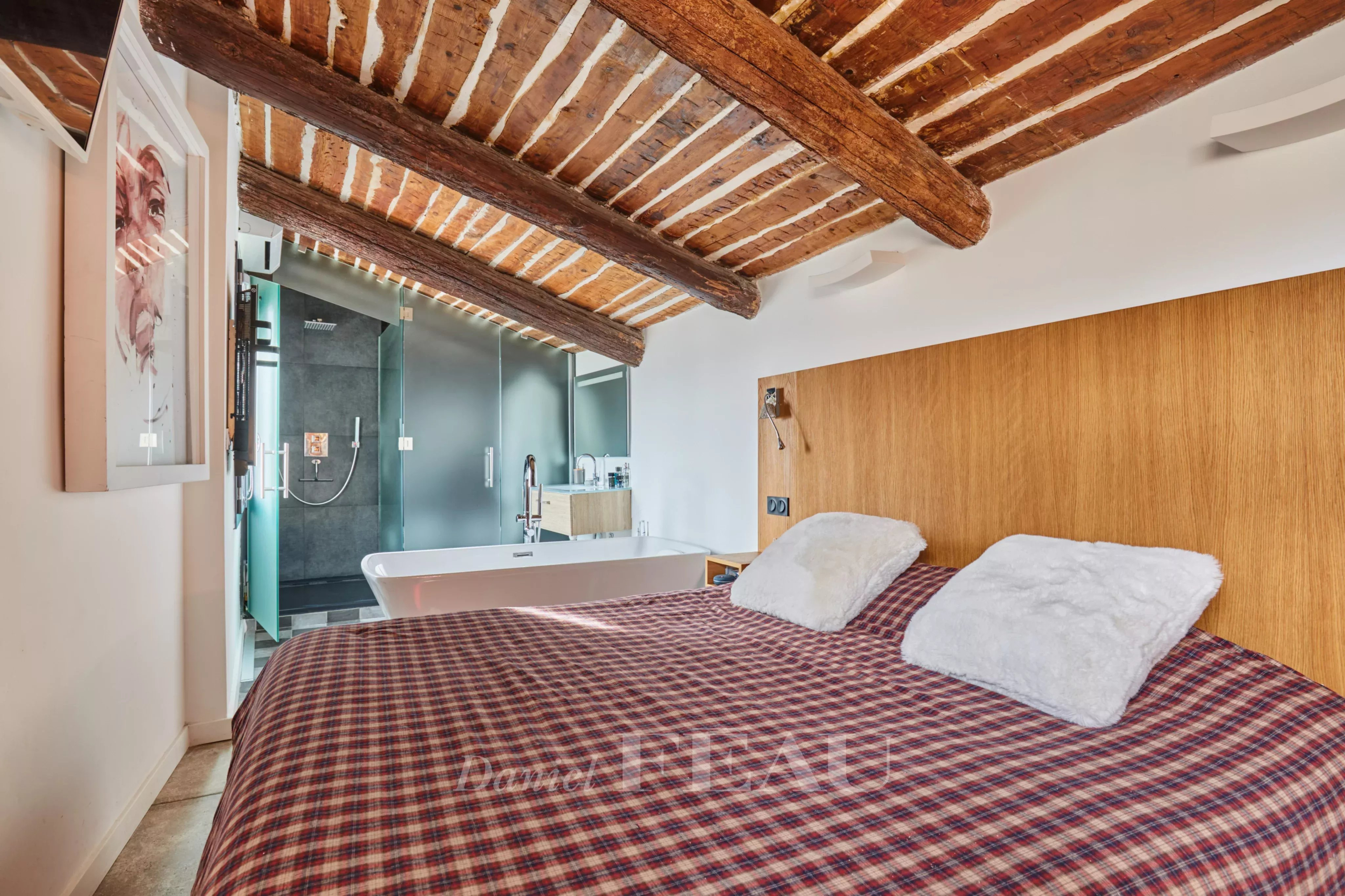 Chambre du loft d’architecte Chambre d'un loft d'architecte avec un lit et une salle de bain ouverte à Aix-en-Provence.