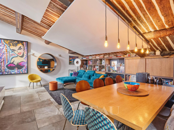 Intérieur d'un loft d'architecte avec terrasse à Aix-en-Provence, mobilier moderne et poutres apparentes.