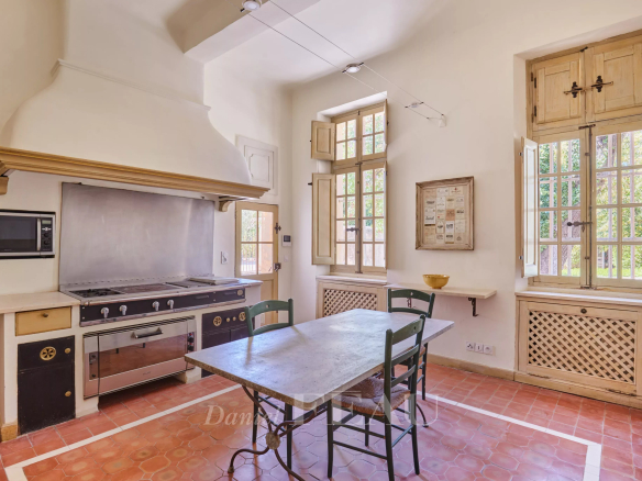 Cuisine d'une bastide du XVIIIème siècle à Aix-en-Provence avec table et fenêtres lumineuses.