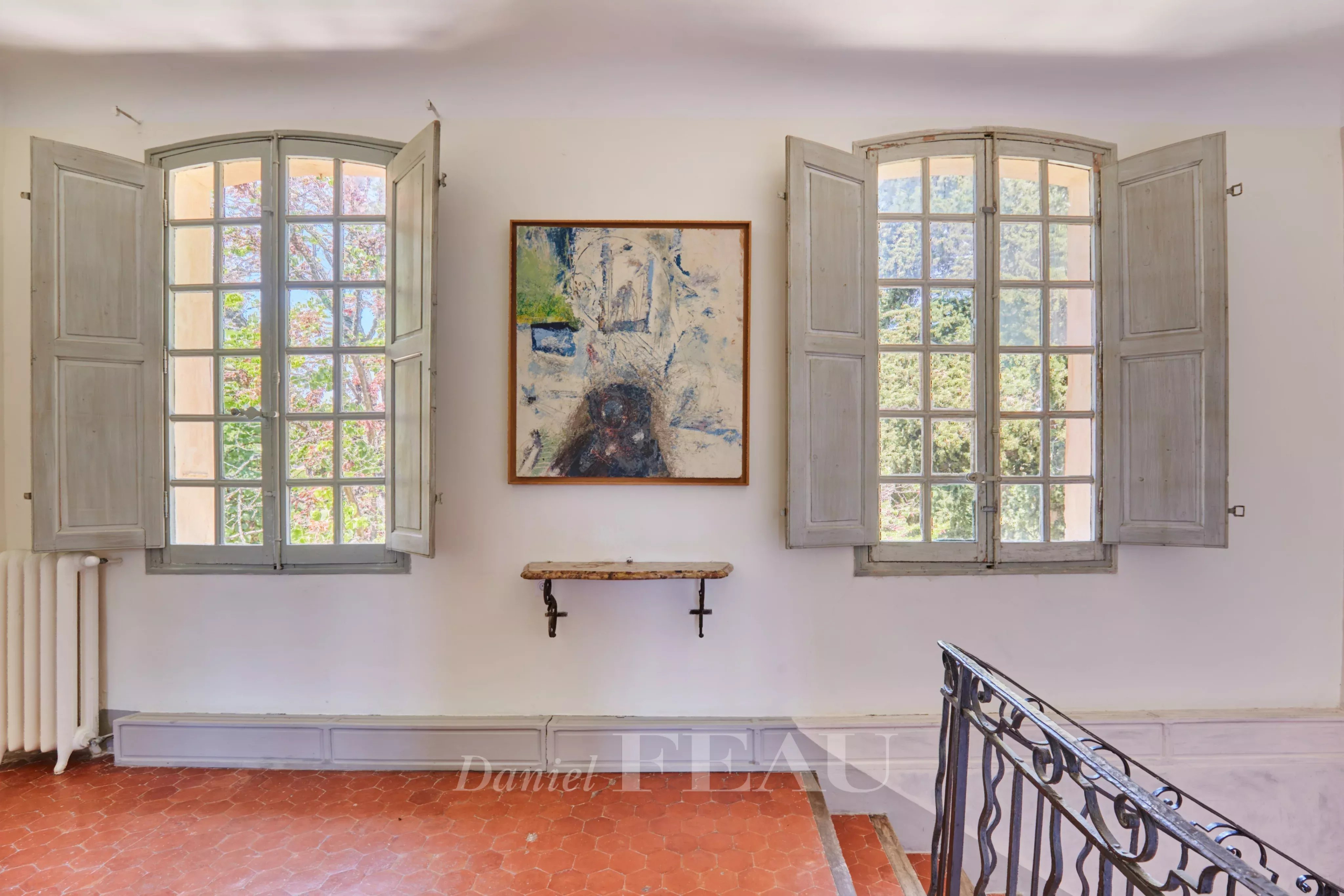 Intérieur d'une bastide du XVIIIème siècle avec fenêtres à volets et tableau au mur.