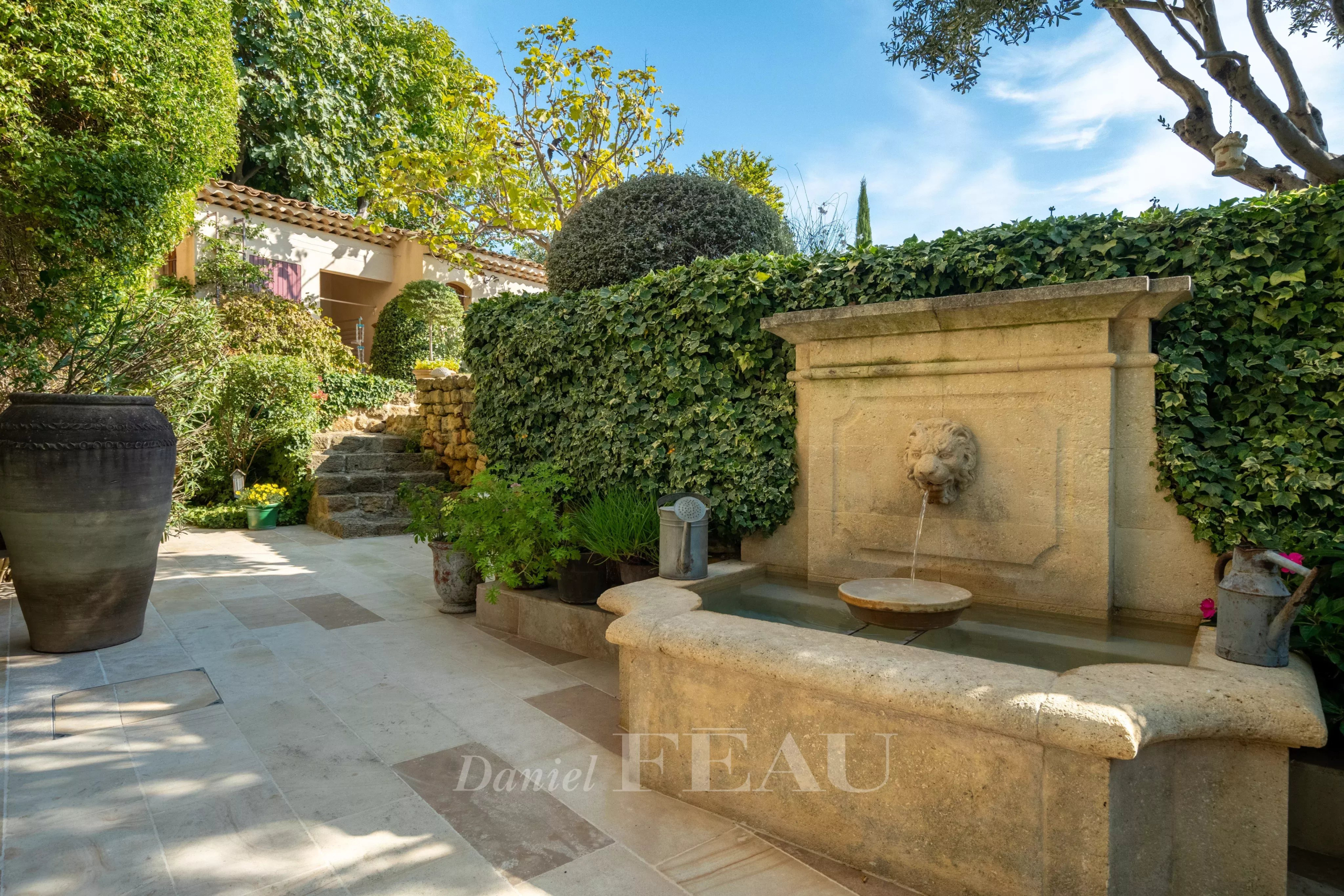 Garden of a former rectory Garden with stone fountain and lush vegetation, restored old presbytery.