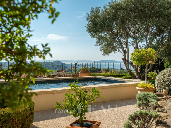 View of a garden with swimming pool and natural landscape in the background, near Aix-en-Provence.