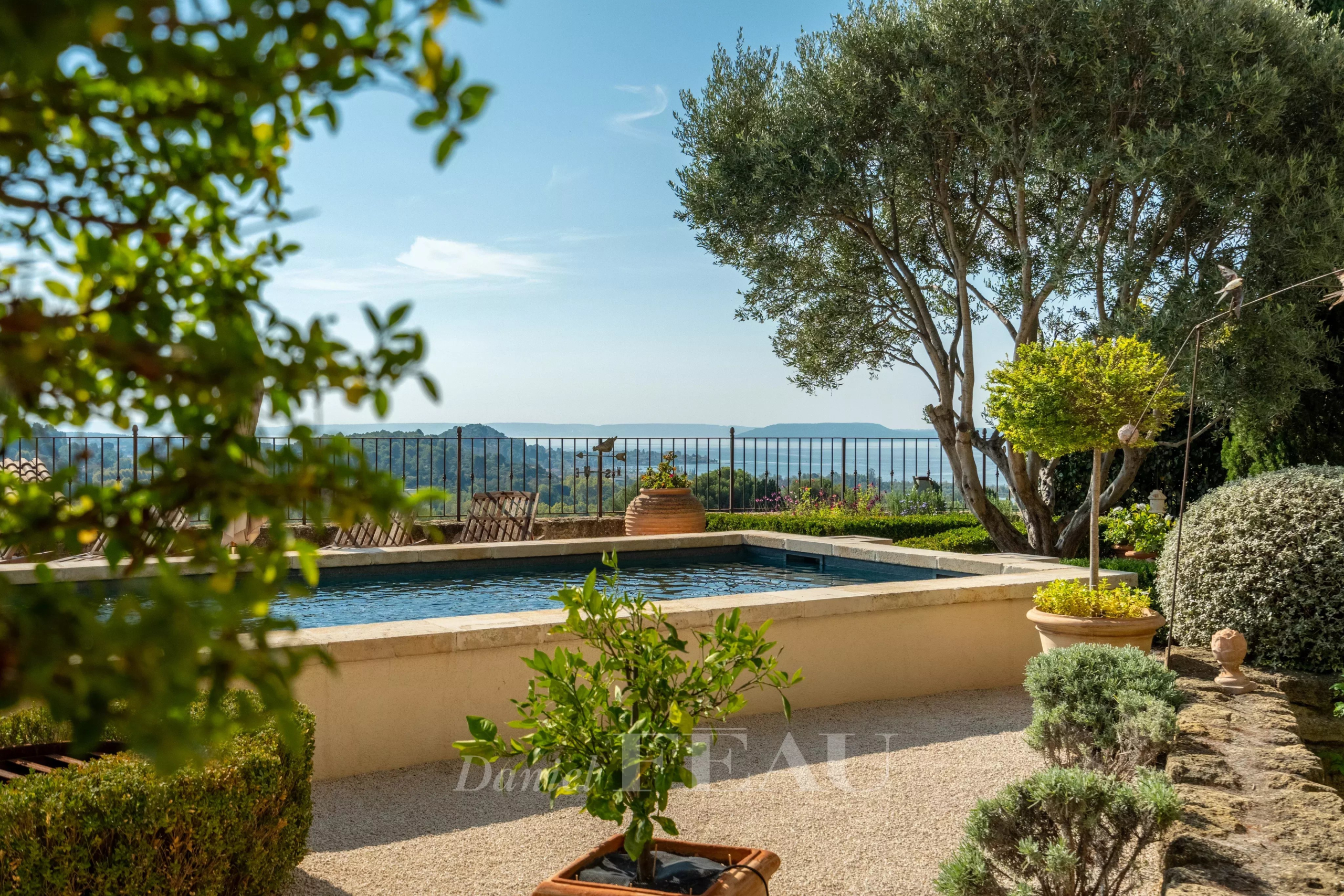 Stone house with panoramic views View of a garden with swimming pool and natural landscape in the background, near Aix-en-Provence.