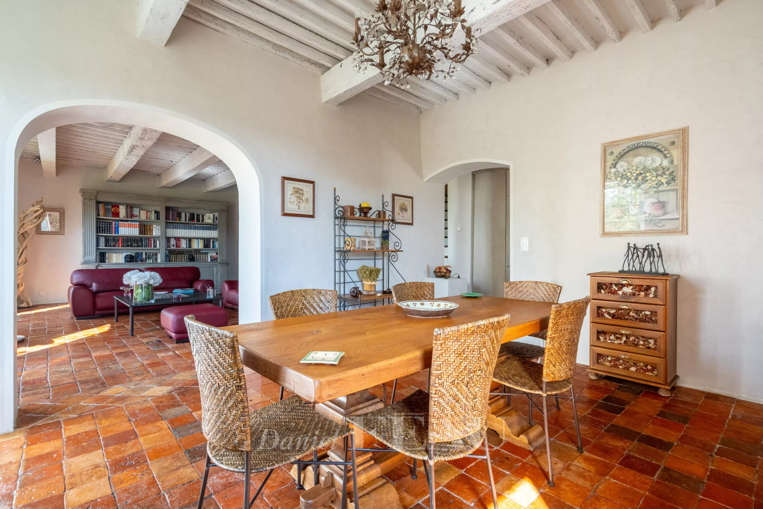 Interior of a historic residence Interior of an 18th-century stone house with a wooden table and wicker chairs.
