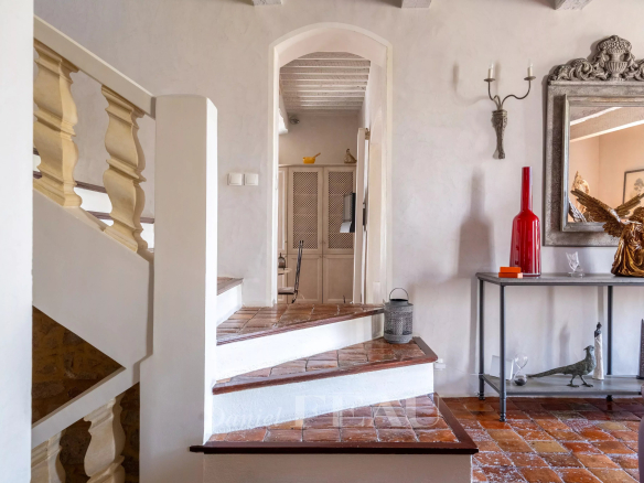 Stone staircase with wooden railing in a restored old house.