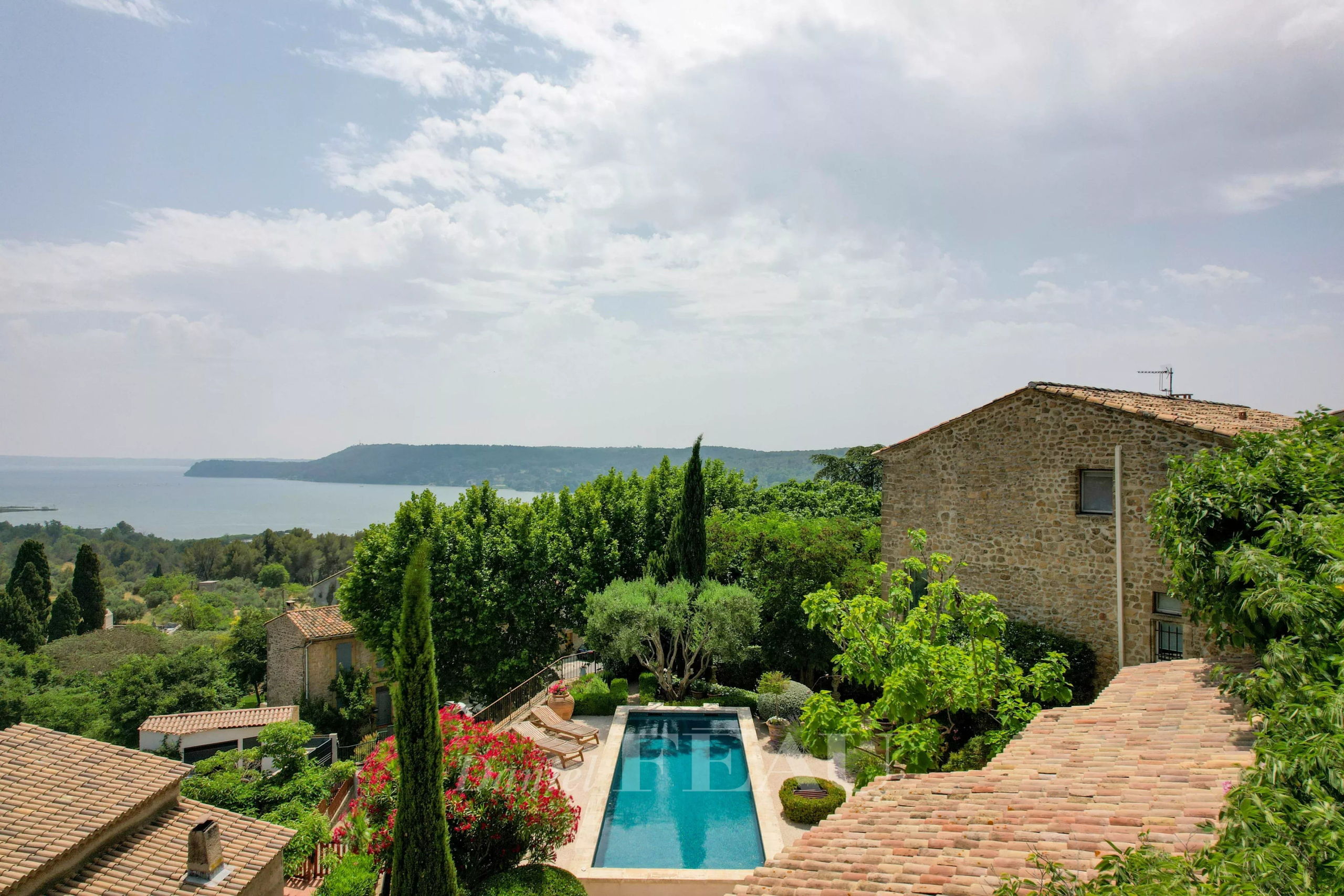 Stone house with swimming pool Panoramic view of a stone house with a swimming pool, surrounded by greenery and natural landscapes.