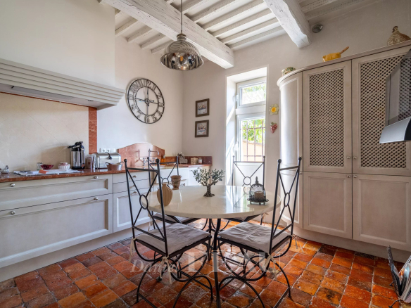 Kitchen of an old 18th-century stone presbytery, with wrought iron table and chairs.