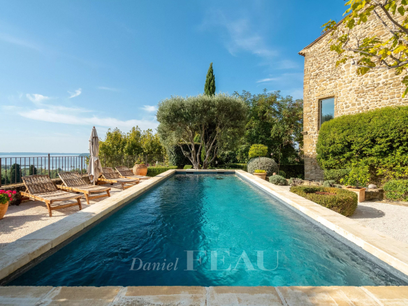 Swimming pool surrounded by greenery and sun loungers, with an unobstructed view of nature.