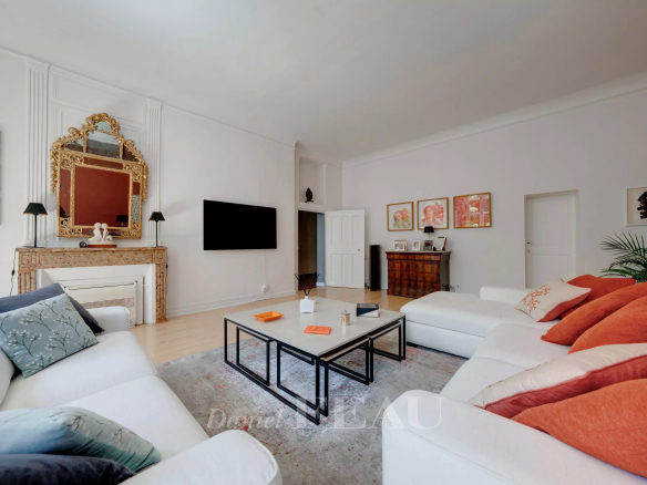 Salon spacieux d'un appartement à Aix-en-Provence avec canapés blancs et coussins colorés.