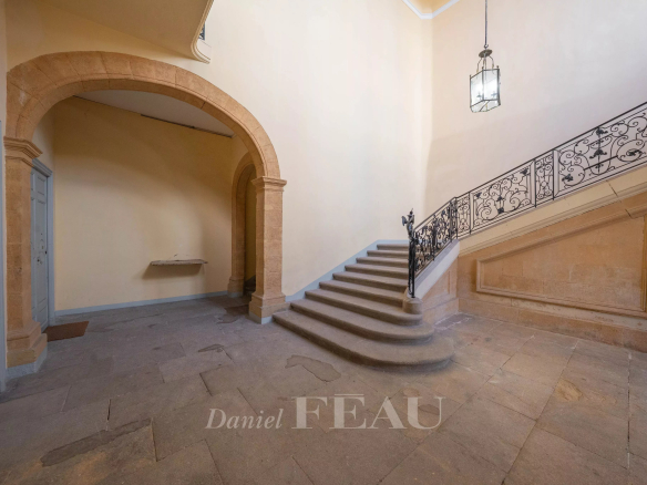 Escalier en pierre avec rampe en fer forgé dans un hôtel particulier à Aix-en-Provence.