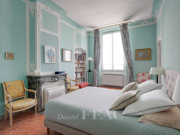 Chambre d'un appartement à Aix-en-Provence avec murs verts et meubles anciens.