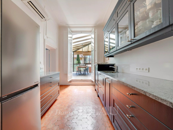 Cuisine moderne avec meubles en bois et accès à une terrasse à Aix-en-Provence.