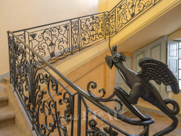 Escalier en colimaçon avec rampe en fer forgé ornée d'un dragon dans un hôtel particulier à Aix-en-Provence.