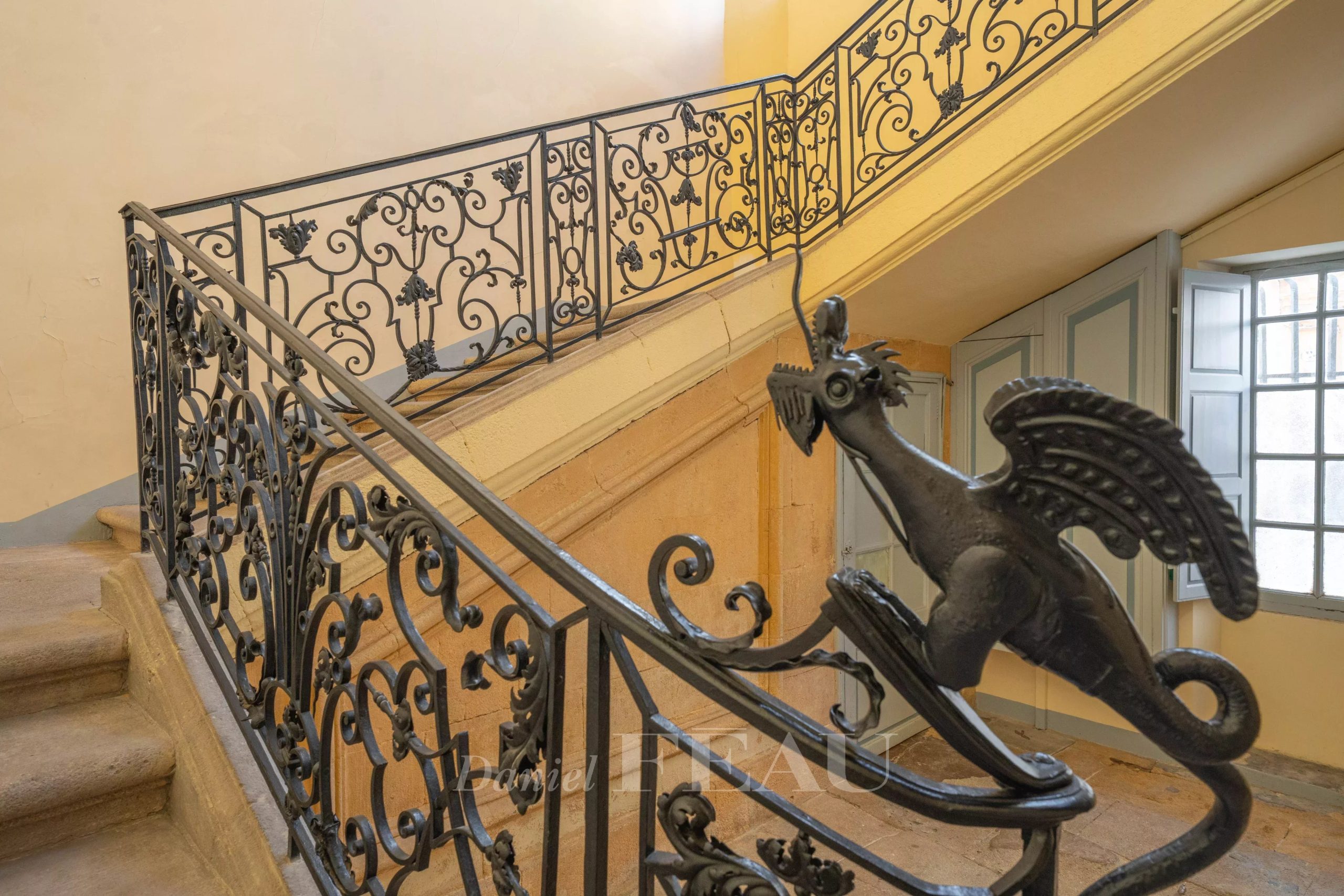 Escalier avec rampe en fer forgé Escalier en colimaçon avec rampe en fer forgé ornée d'un dragon dans un hôtel particulier à Aix-en-Provence.