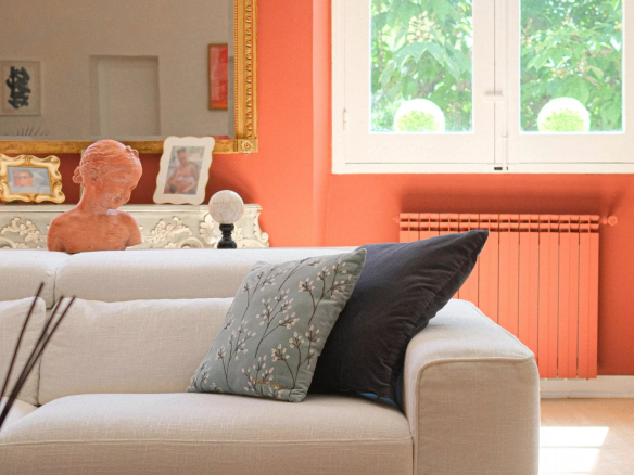 Intérieur d'un appartement à Aix-en-Provence avec un canapé, des coussins et une sculpture sur une table.