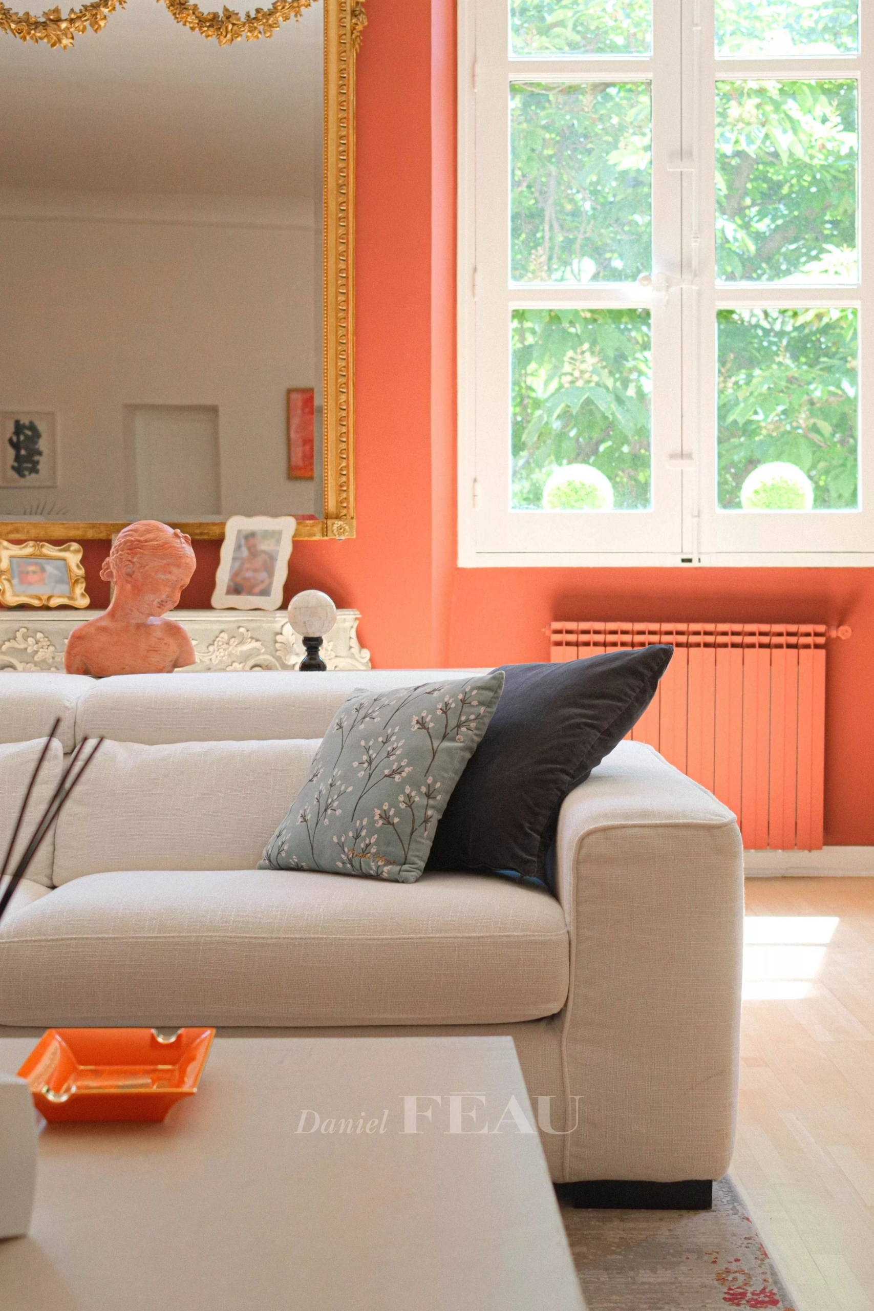 Intérieur d’un appartement à Aix-en-Provence Intérieur d'un appartement à Aix-en-Provence avec un canapé, des coussins et une sculpture sur une table.