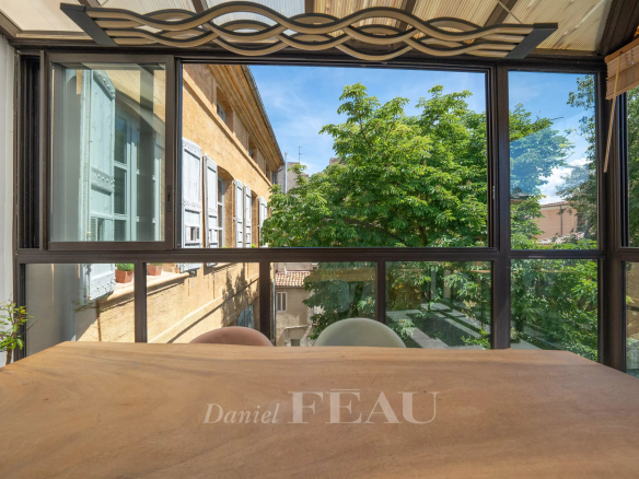 Vue d'une salle à manger avec une grande fenêtre donnant sur des arbres à Aix-en-Provence.